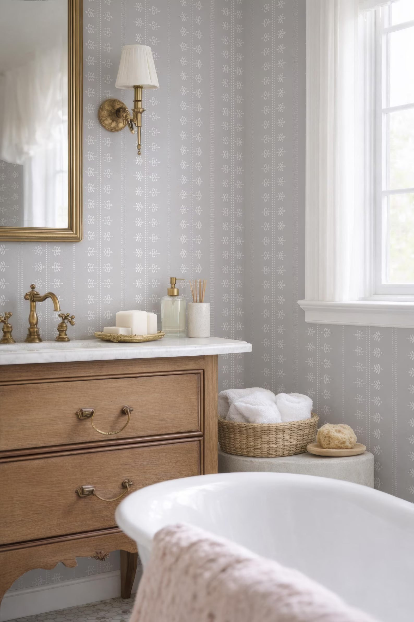 a well-organized bathroom with a wooden vanity, a white bathtub, and a mirror. The bathroom has a neutral color scheme with gray and white walls, and the overall design appears to be elegant and functional.