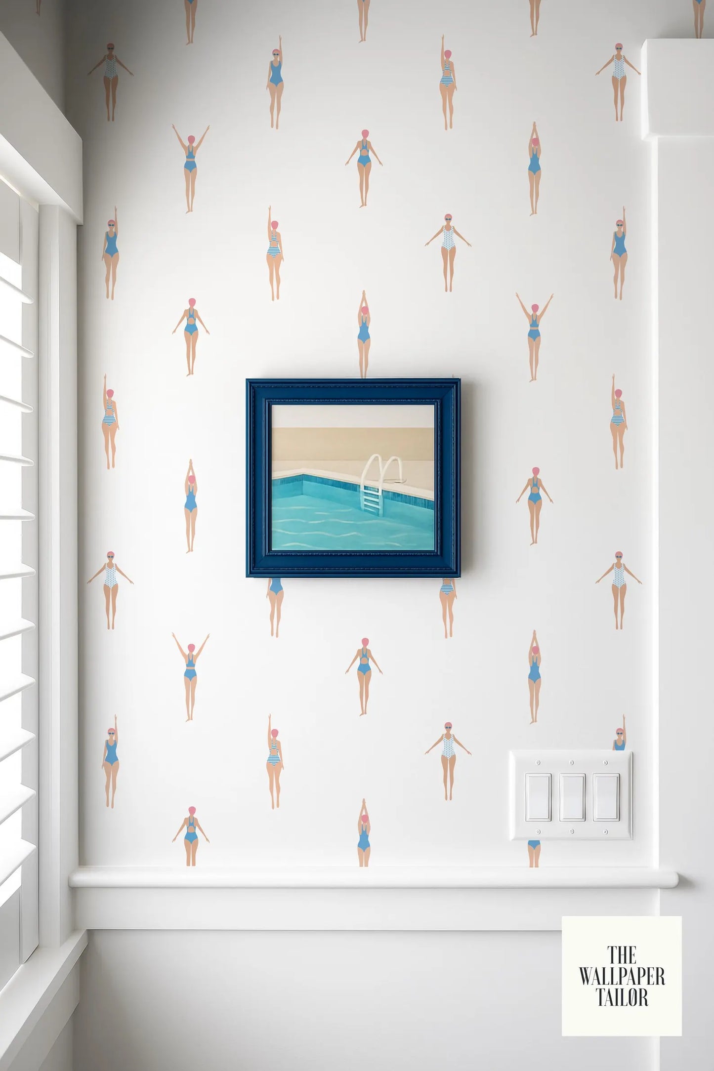 a wallpapered wall with a framed picture of a swimming pool and a white light switch.