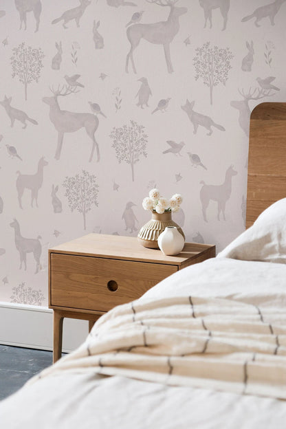 a bedroom with a wooden nightstand and a white vase with flowers on it. The wall behind the nightstand has a repeating pattern of deer and other wildlife silhouettes.
