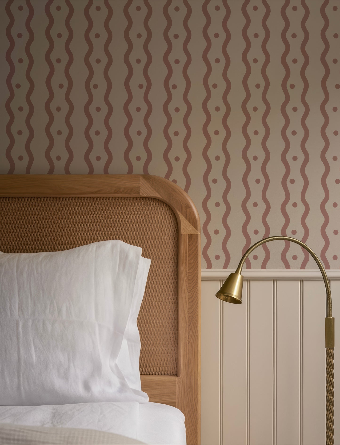 a cozy bedroom scene with a wooden headboard, a white bedding set, and a lamp on a side table.