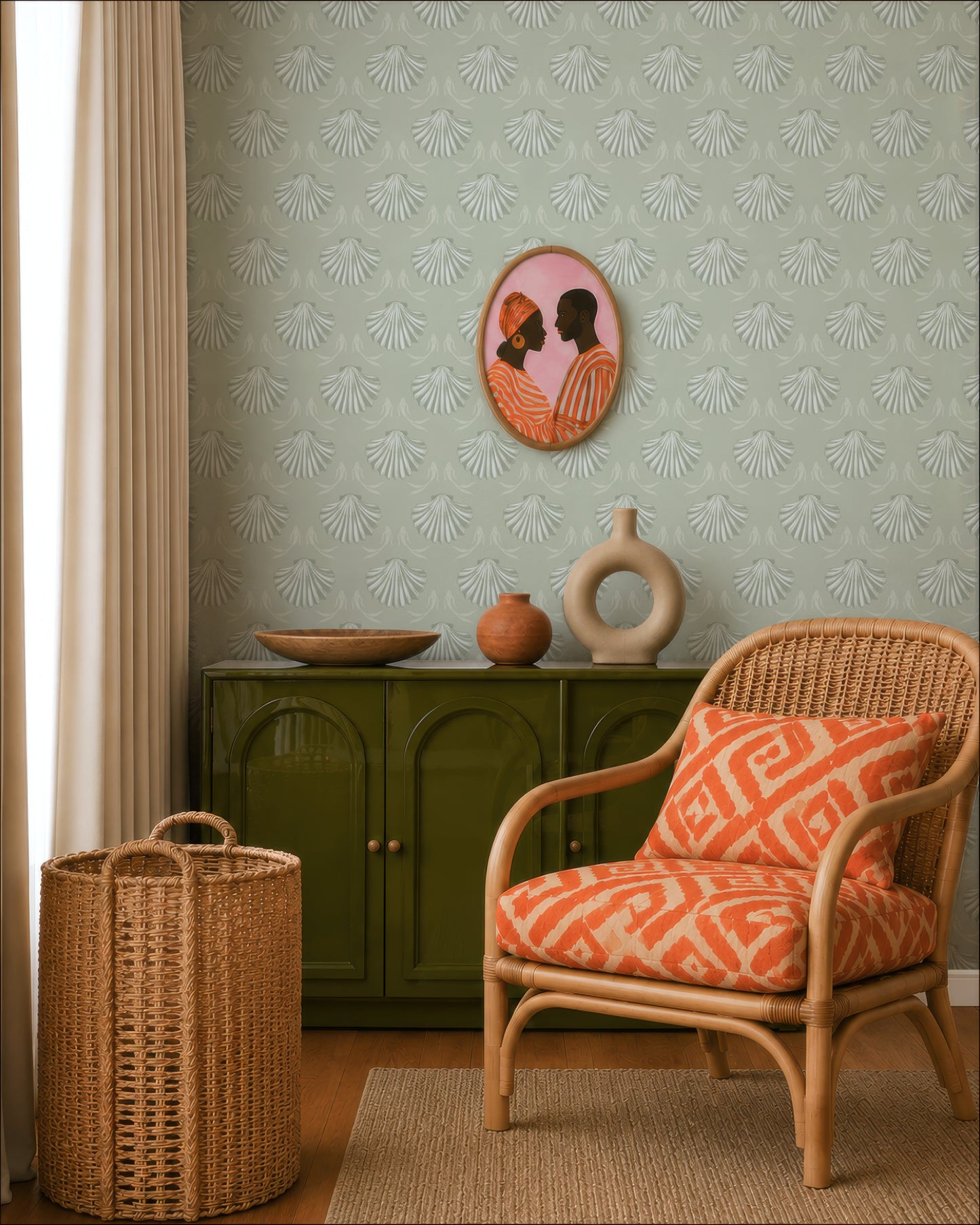 a living room with a wicker chair, a green cabinet, and a decorative vase. The wall has a patterned wallpaper, and there is a framed picture of a man and a woman hanging on the wall.