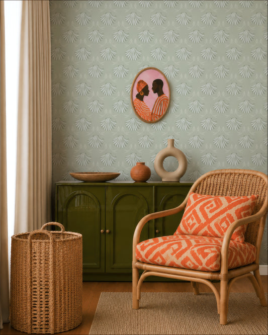 a living room with a wicker chair, a green cabinet, and a decorative vase. The wall has a patterned wallpaper, and there is a framed picture of a man and a woman hanging on the wall.