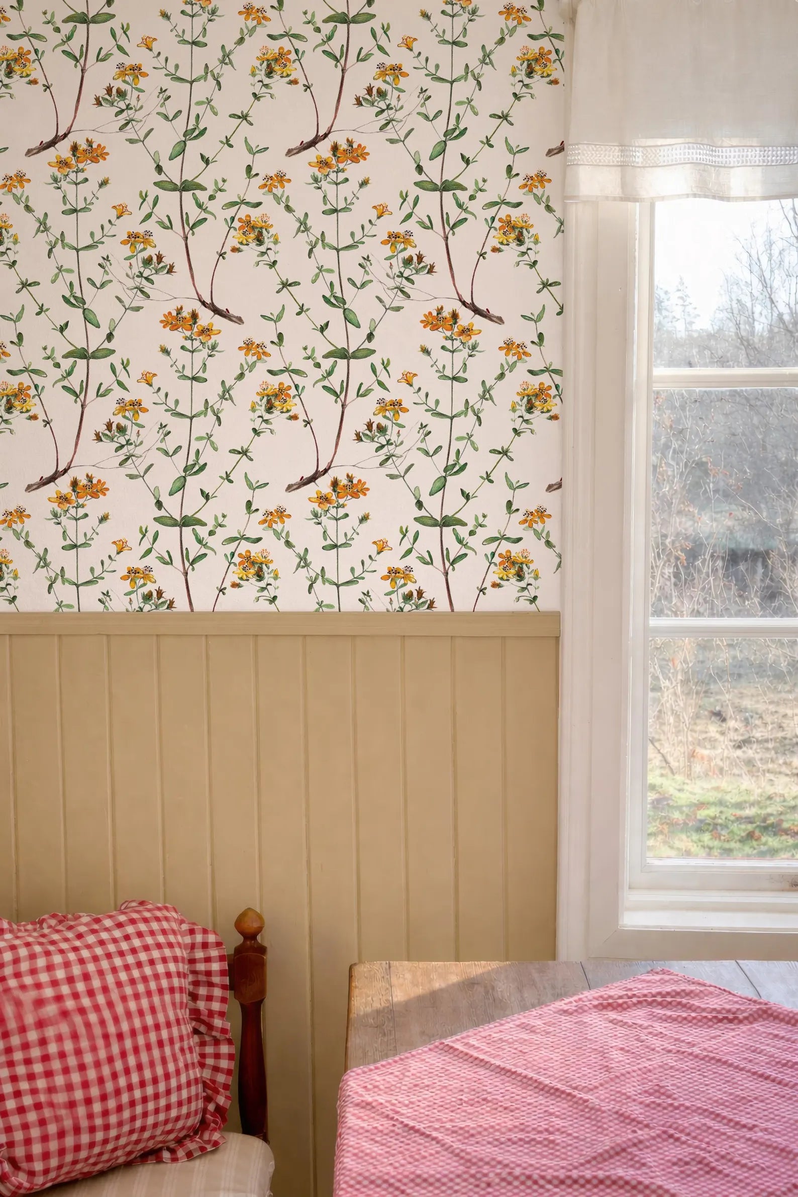 a cozy bedroom with a floral wallpaper pattern, a wooden headboard, and a window overlooking a garden.