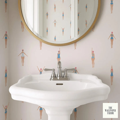 a bathroom sink with a round mirror above it, and the wall behind the sink has a repeating pattern of swimming figures.