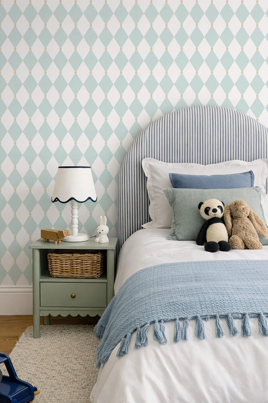a cozy and inviting bedroom scene, featuring a bed with a blue blanket and a striped headboard, a nightstand with a lamp and a small stuffed animal, and a blue and white patterned wallpaper.