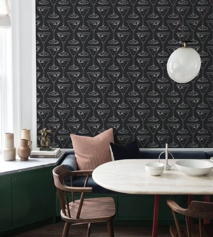 a dining area with a black and white patterned wallpaper, a white table, and a wooden chair. There are also some decorative elements such as vases and bowls on the table.