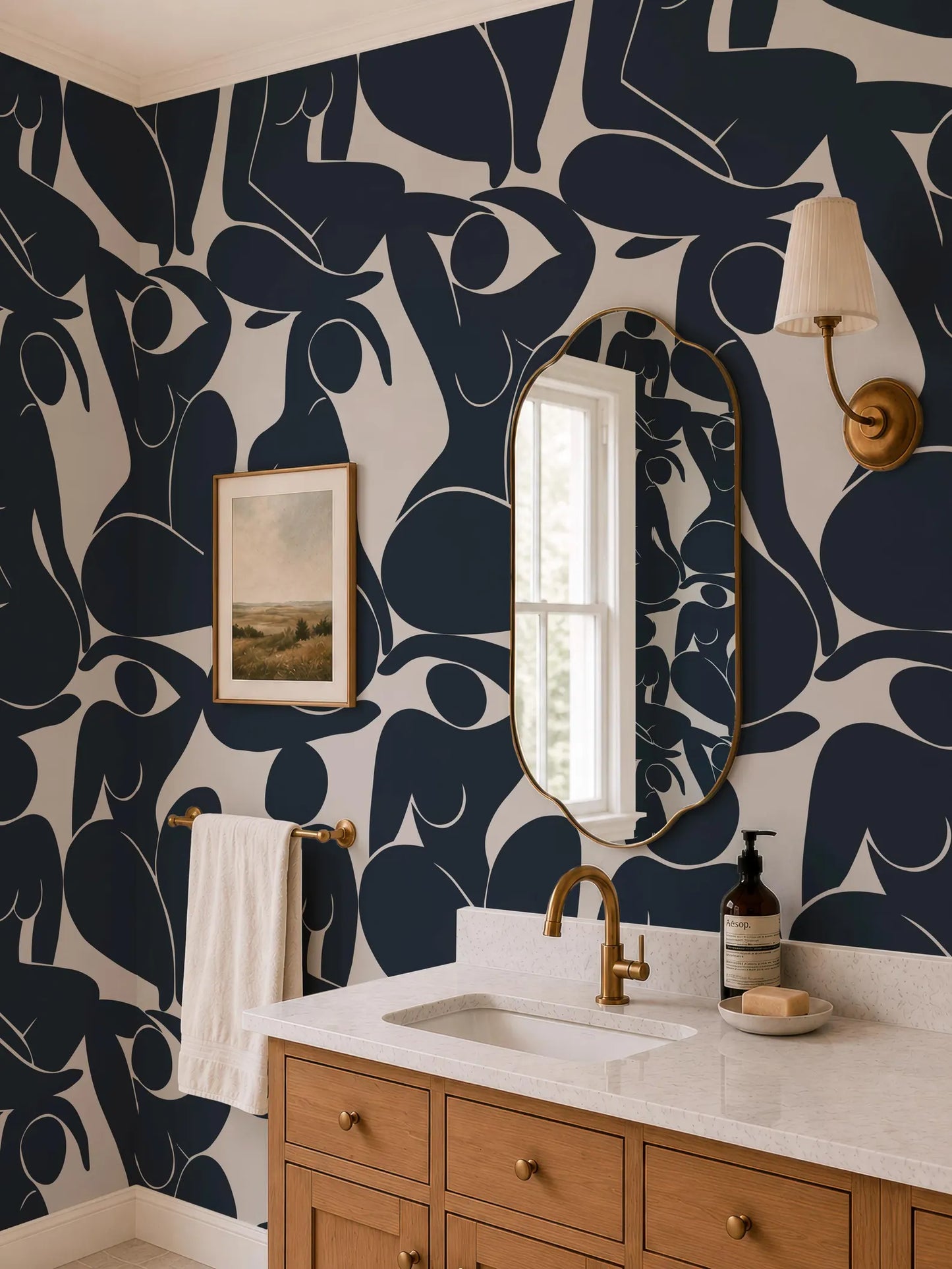 a bathroom with a white sink, a gold faucet, and a mirror above it. The walls are decorated with a black and white abstract pattern, and there is a painting hanging on the wall. The bathroom also has a wooden vanity and a lamp on the wall.