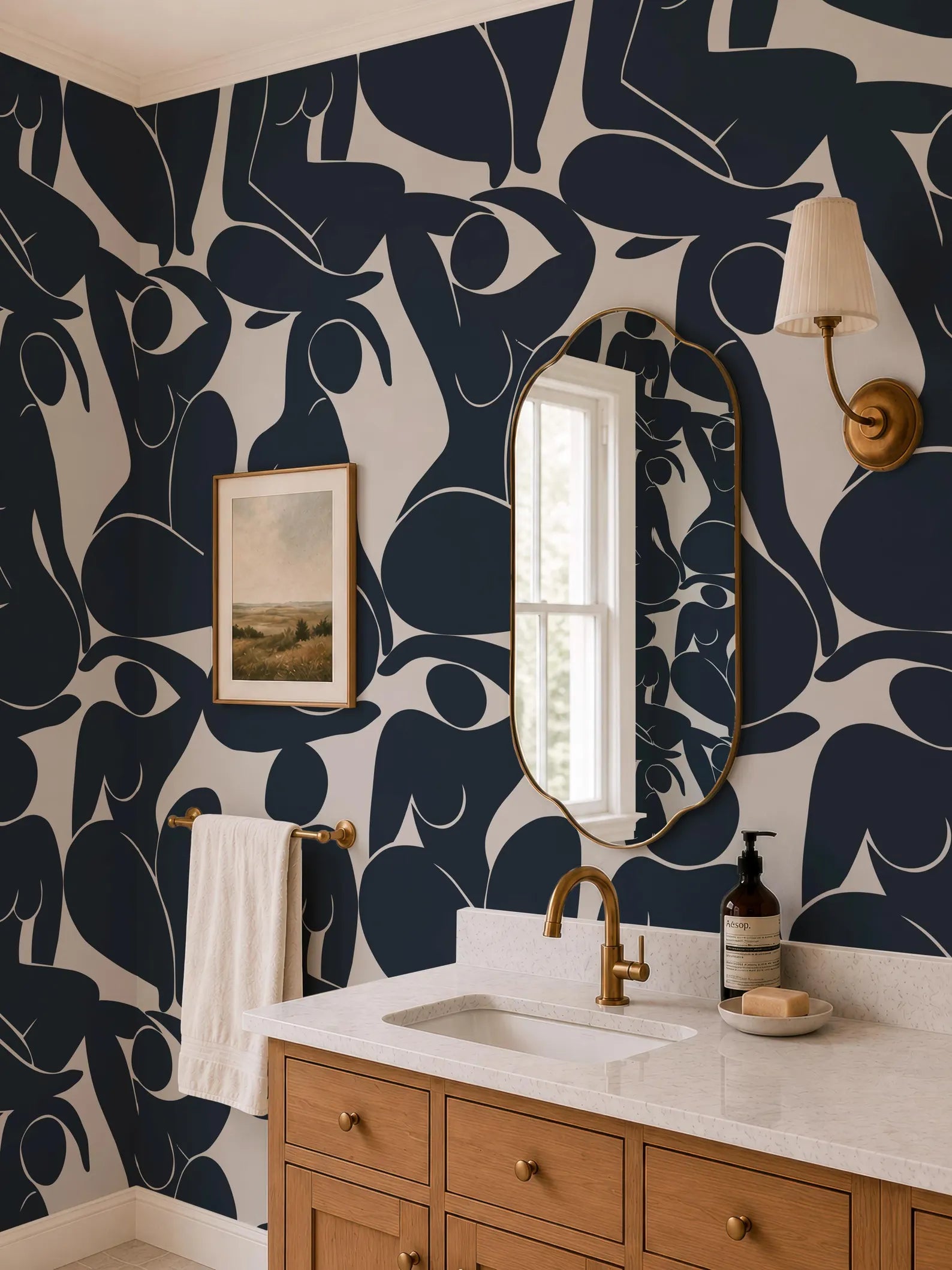 a bathroom with a white sink, a gold faucet, and a mirror above it. The walls are decorated with a black and white abstract pattern, and there is a painting hanging on the wall. The bathroom also has a wooden vanity and a lamp on the wall.