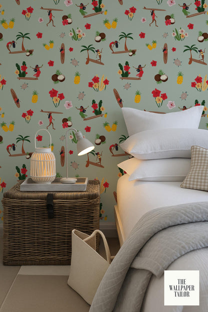 a bedroom with a wicker side table, a white lamp, and a bed with white pillows. The wall behind the bed is decorated with a colorful, tropical-themed wallpaper featuring various illustrations of people, palm trees, and other tropical elements.