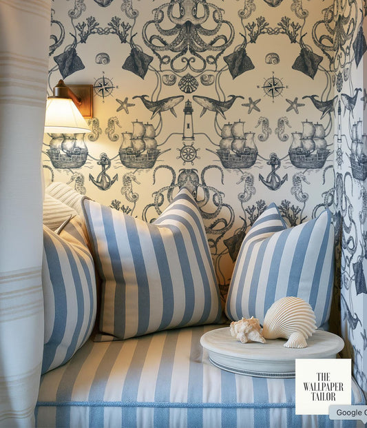 a cozy nautical-themed room with a striped cushion, a small table with a seashell, and a wallpapered wall with various nautical illustrations.