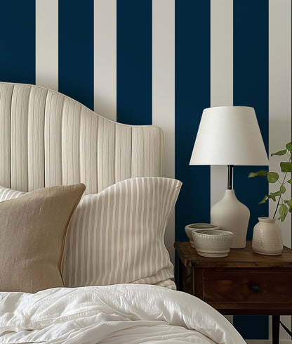 a bed with a white and blue striped headboard