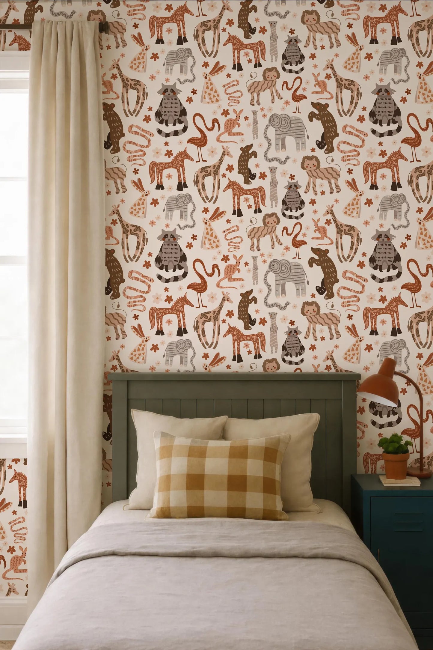 a bedroom with a bed, a nightstand, and a window with a beige curtain. The wall behind the bed is covered in a patterned wallpaper featuring various animals, including giraffes, elephants, and flamingos.