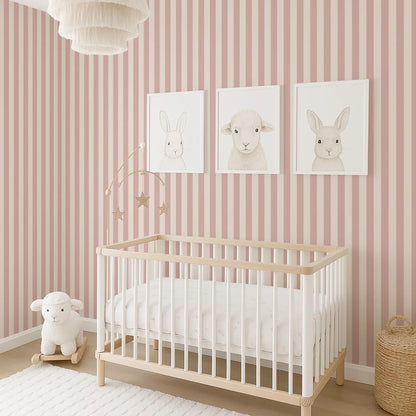 A nursery room with a white crib, pink and white striped wallpaper, and three framed animal drawings on the wall.