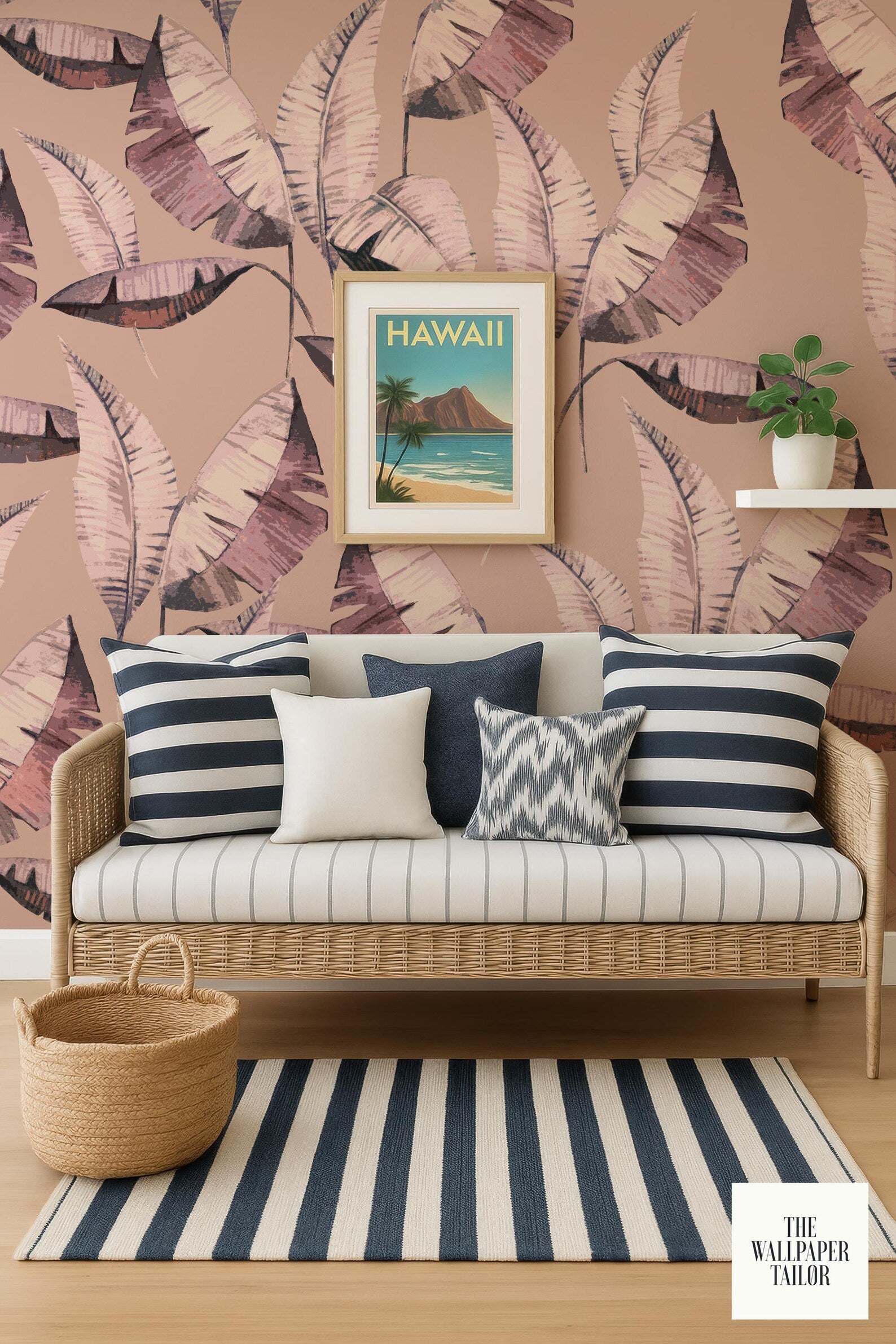 a cozy living room with a wicker sofa adorned with striped pillows and a framed picture of a tropical beach. The wall behind the sofa is covered in a vibrant wallpaper pattern of palm leaves, and a basket is placed on the floor next to the sofa.