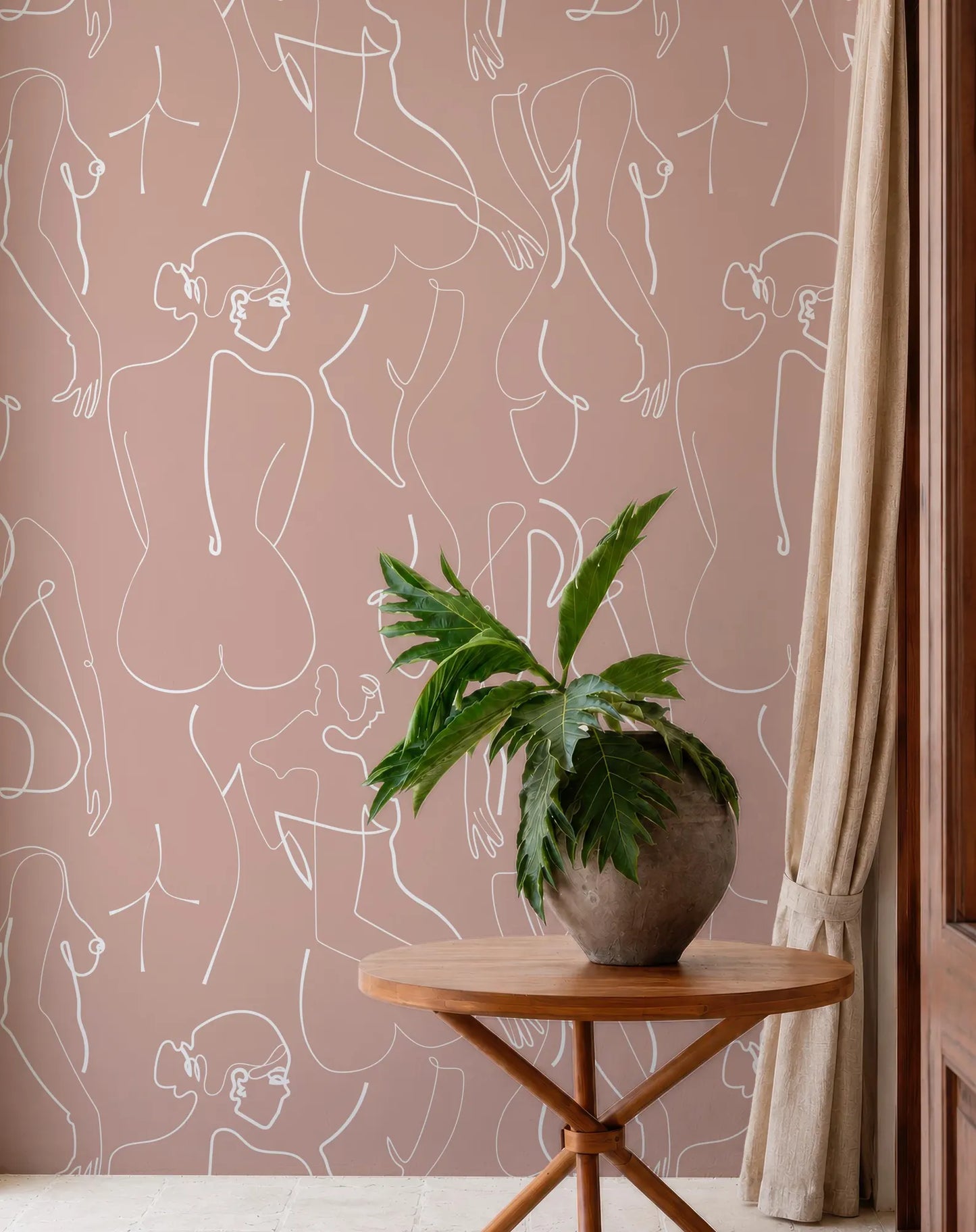 a wooden table with a potted plant on it, set against a wall with a repeating pattern of abstract human-like figures in white lines.