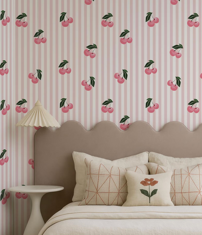 a bedroom with a bed, a headboard, and a wallpapered wall with a repeating pattern of pink and green cherries.