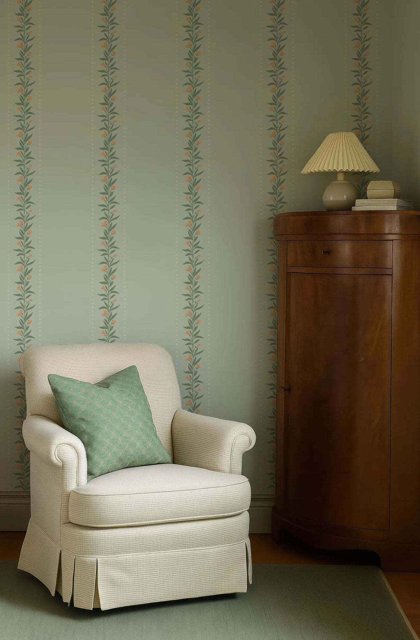 a cozy corner of a room with a white armchair, a wooden cabinet, and a green and white striped wallpaper.