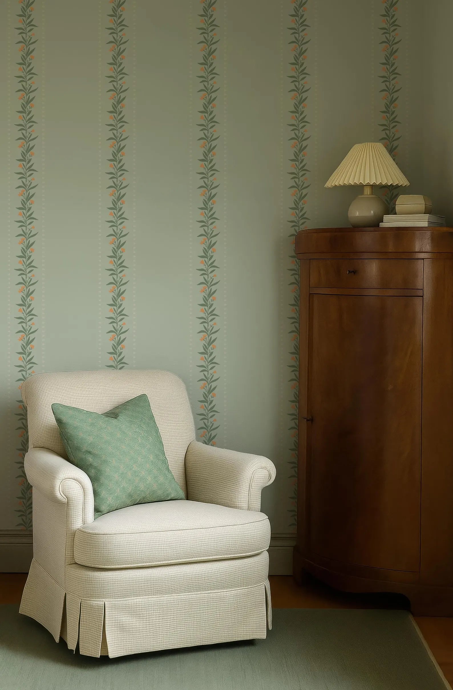 a cozy corner of a room with a white armchair, a wooden cabinet, and a green and white striped wallpaper.