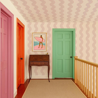 a hallway with a wooden desk, a green door, and a pink door. The hallway has a colorful and vibrant atmosphere, with the walls and doorways painted in various shades of pink, green, and orange.
