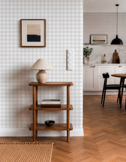 a cozy and well-organized living space with a wooden side table, a lamp, and a framed picture on the wall. The room has a checkered wallpaper, a wooden floor, and a dining table with chairs. The overall design and arrangement of the space create a warm and inviting atmosphere.