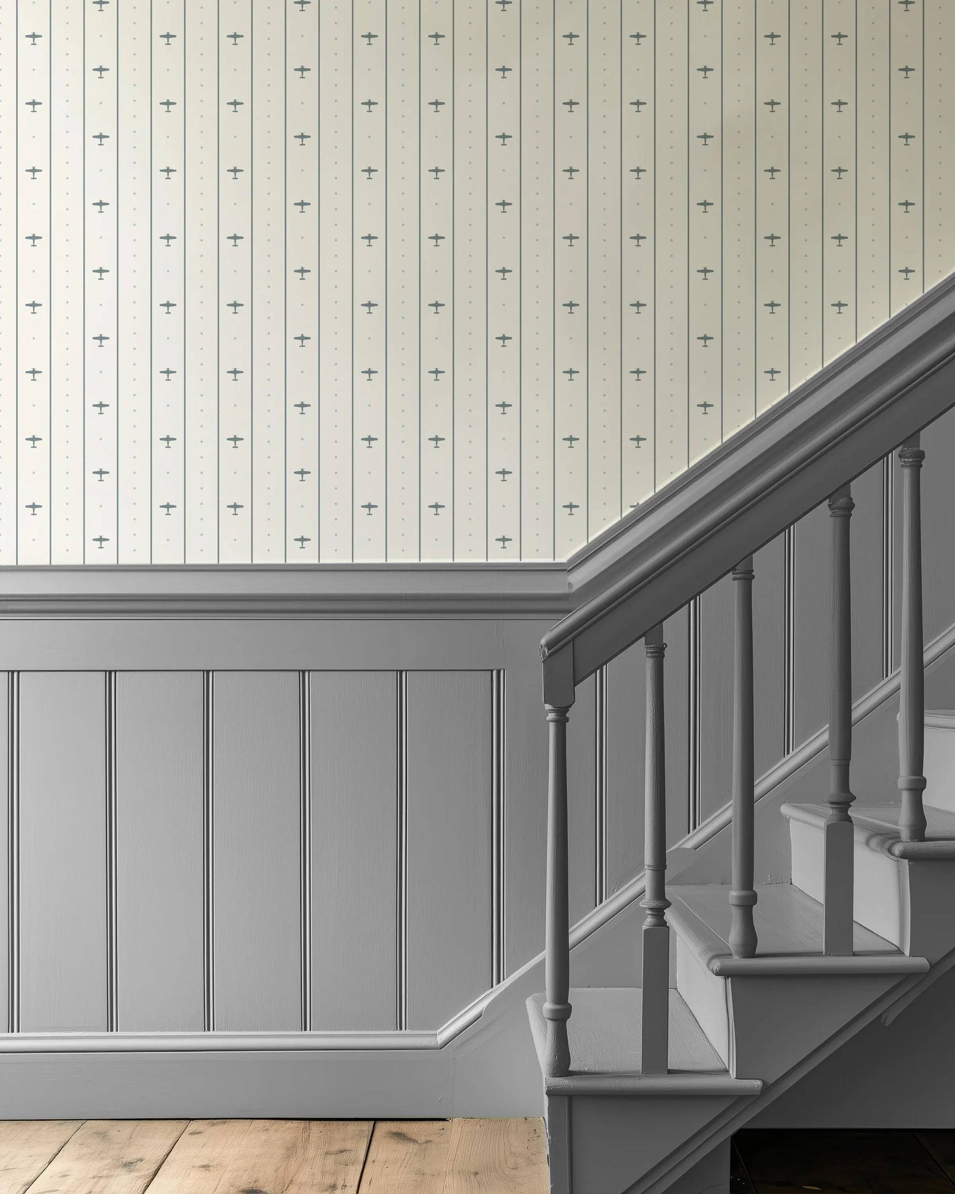 a staircase with a gray railing and a wooden floor. The walls are adorned with a patterned wallpaper, and the overall color scheme is neutral, with a gray and white color palette.