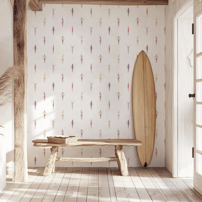 a wooden bench, a surfboard, and a wall with a pattern of colorful figures, creating a beach-themed atmosphere.