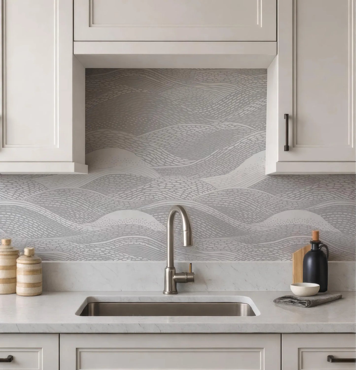a modern kitchen with a sink, cabinets, and a decorative backsplash with a wave pattern.