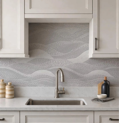 a modern kitchen with a sink, cabinets, and a decorative backsplash with a wave pattern.
