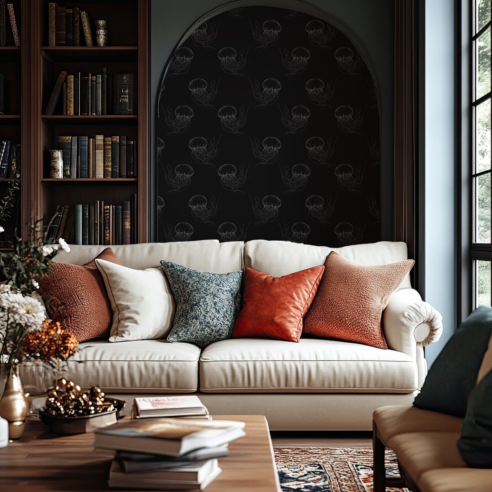 a cozy living room with a white sofa adorned with colorful throw pillows, a wooden coffee table, and a bookshelf filled with books. The room has a dark, moody atmosphere with a black and white patterned wallpaper, and a large arched window that allows natural light to enter the space.