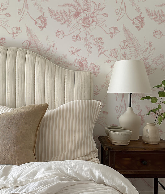 a bed with a white headboard sitting next to a lamp