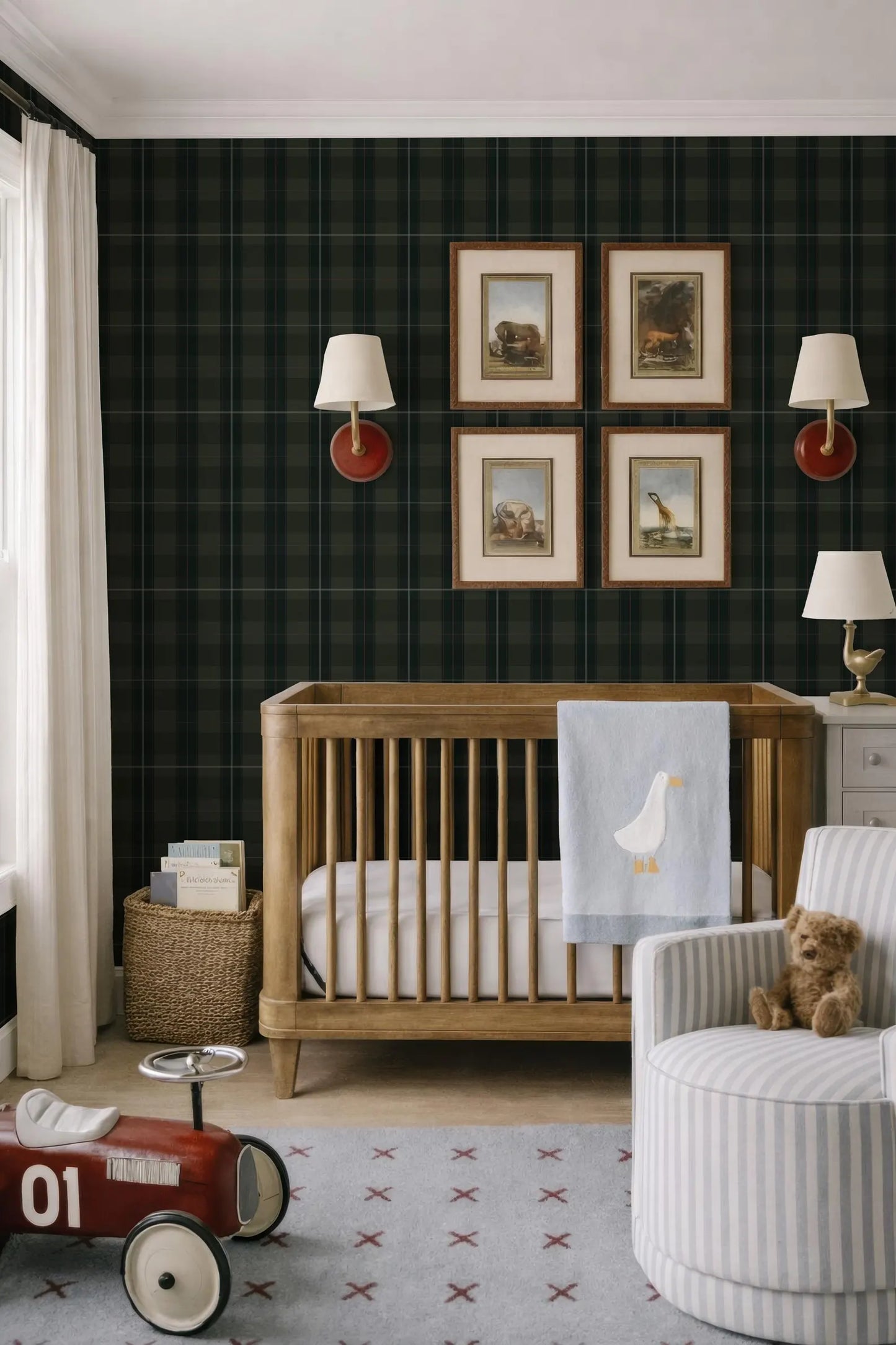 a cozy nursery with a wooden crib, a red toy car, and a striped armchair. The walls are covered in a dark green plaid wallpaper, and there are four framed pictures hanging above the crib.