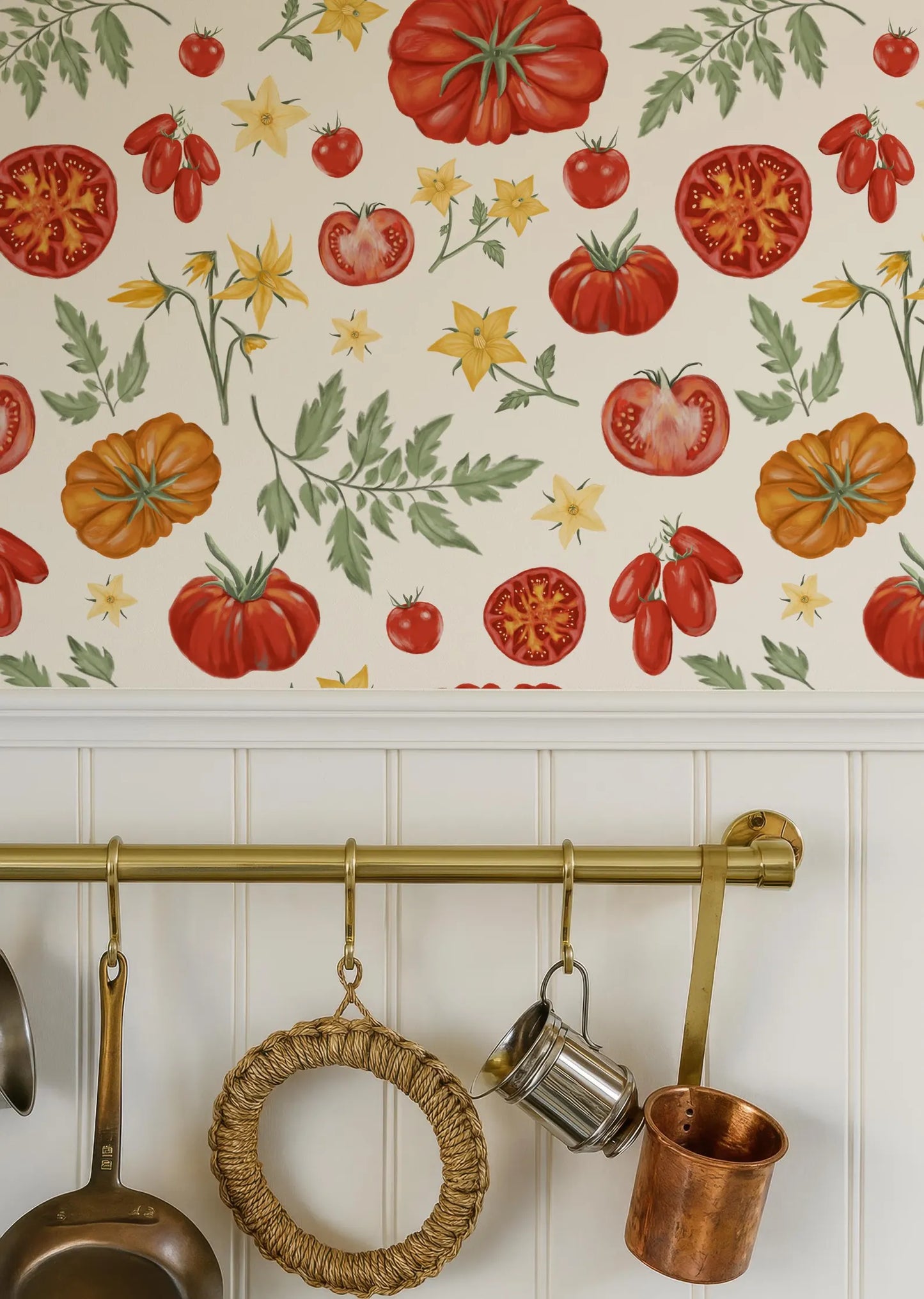 a kitchen wall with a pattern of red tomatoes and yellow flowers, creating a vibrant and lively atmosphere. The wall is adorned with a variety of kitchen utensils, including a copper pot, a copper mug, and a woven pot, adding a rustic touch to the overall design.