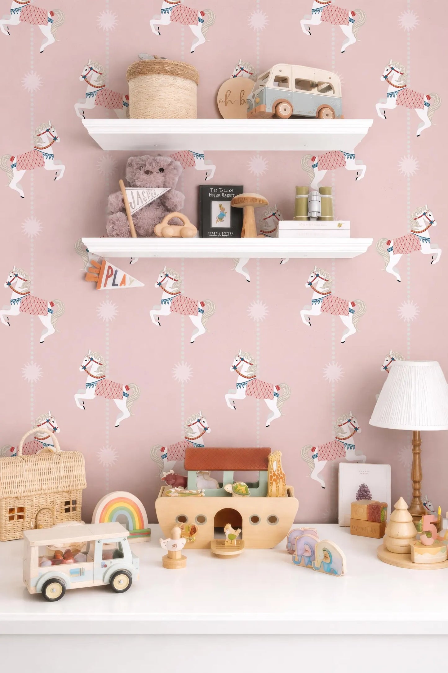 a child's bedroom with a pink and white color scheme, decorated with various toys and a shelf displaying a collection of items.