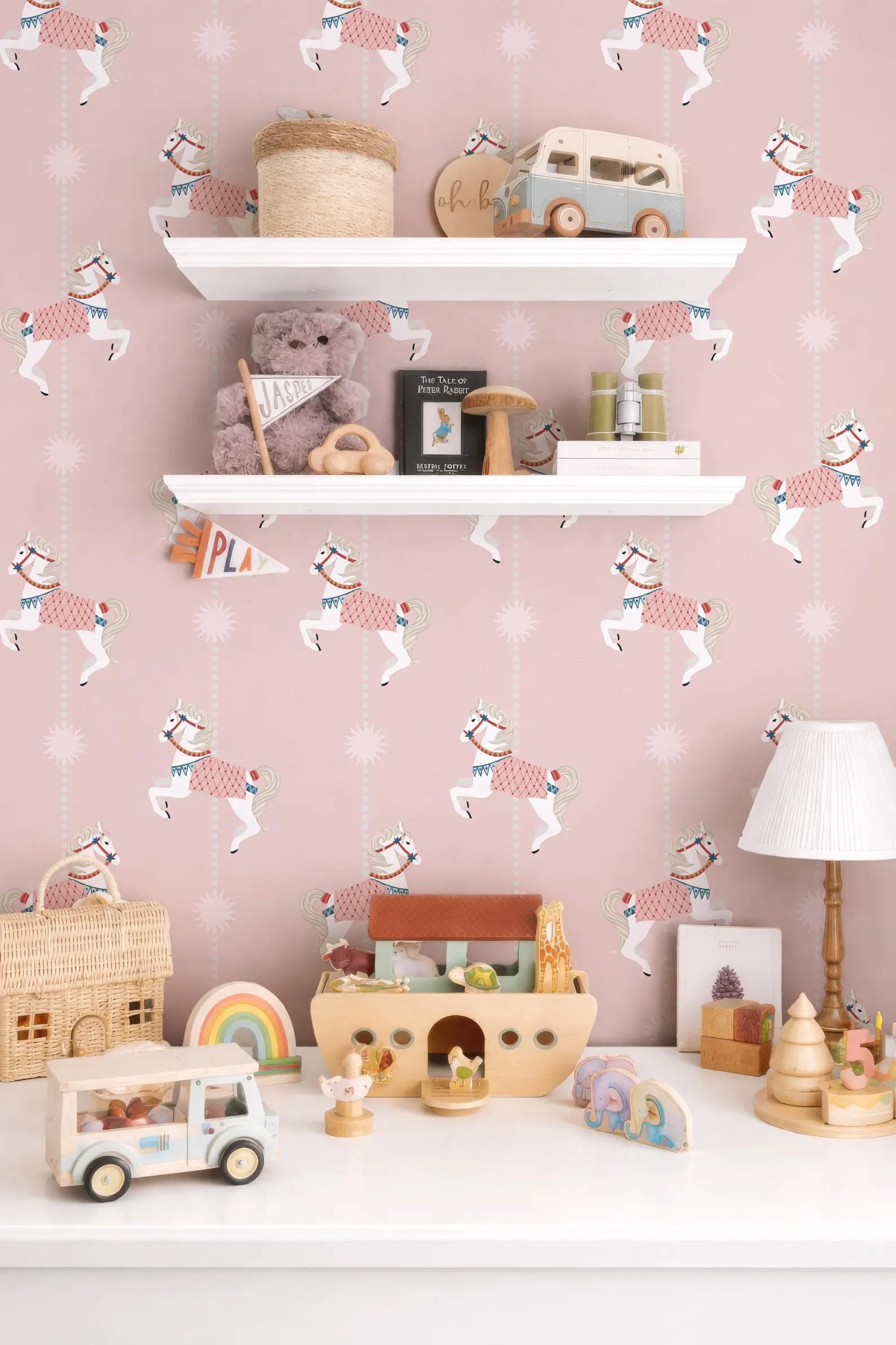 a child's bedroom with a pink and white color scheme, decorated with various toys and a shelf displaying a collection of items.