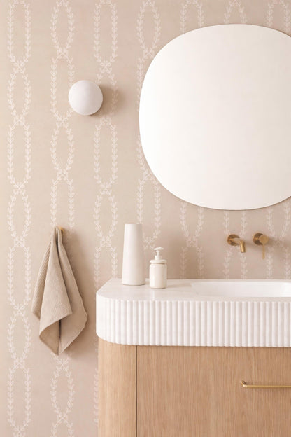 a bathroom with a white sink, a round mirror, and a towel hanging on a hook. The bathroom has a minimalist and modern design, with a white color scheme and a wooden vanity.