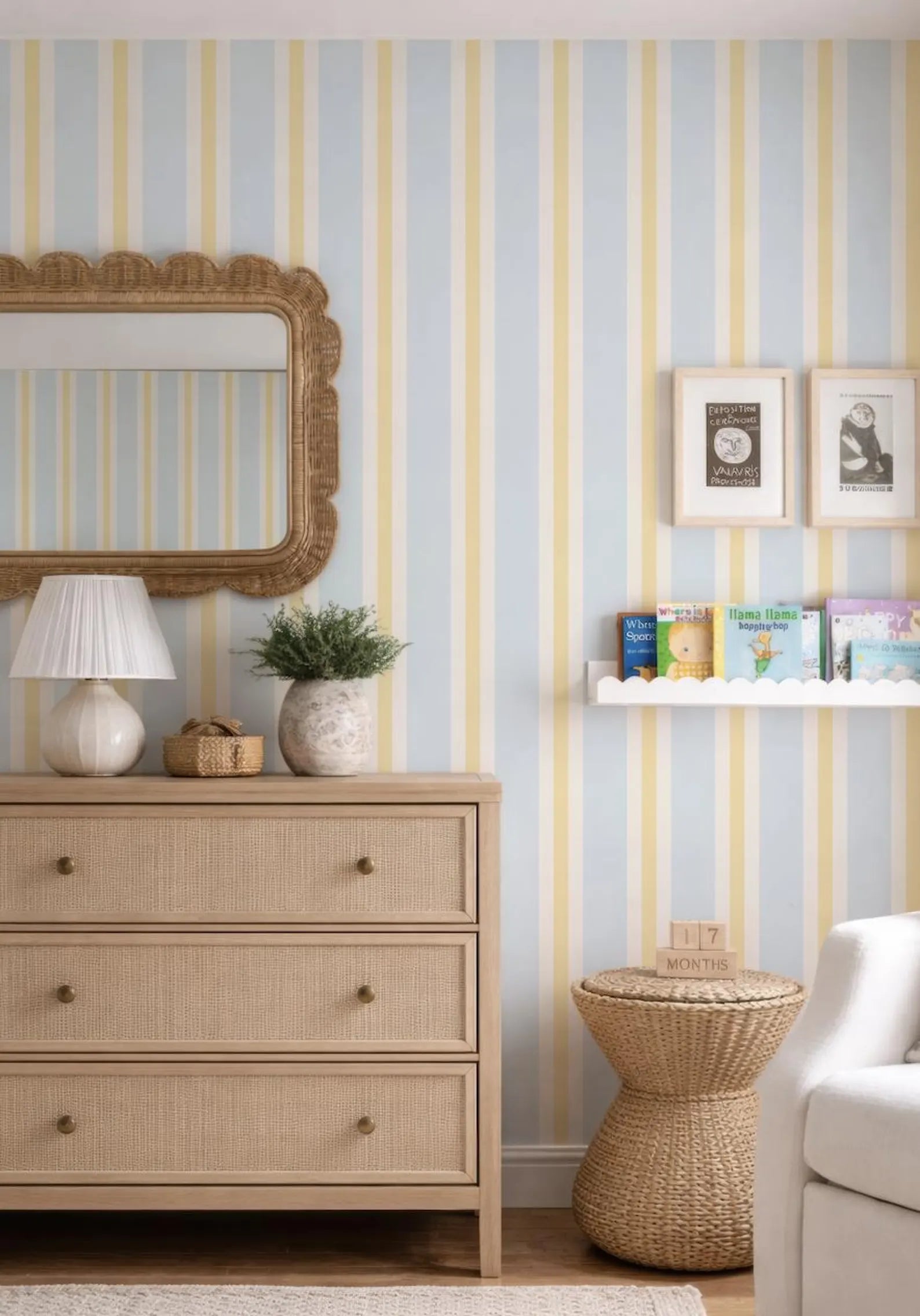 a cozy and well-decorated living room with a striped wallpaper, a wooden dresser, a mirror, and a bookshelf.