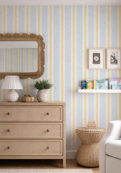 a cozy and well-decorated living room with a striped wallpaper, a wooden dresser, a mirror, and a bookshelf.