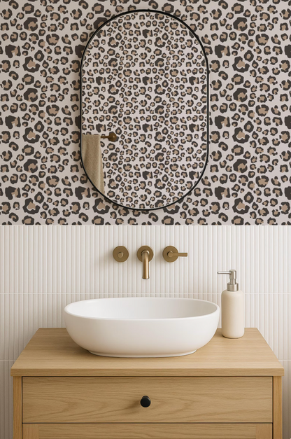 a bathroom with a white oval-shaped sink, a mirror with a leopard print frame, and a wooden vanity with a white soap dispenser.