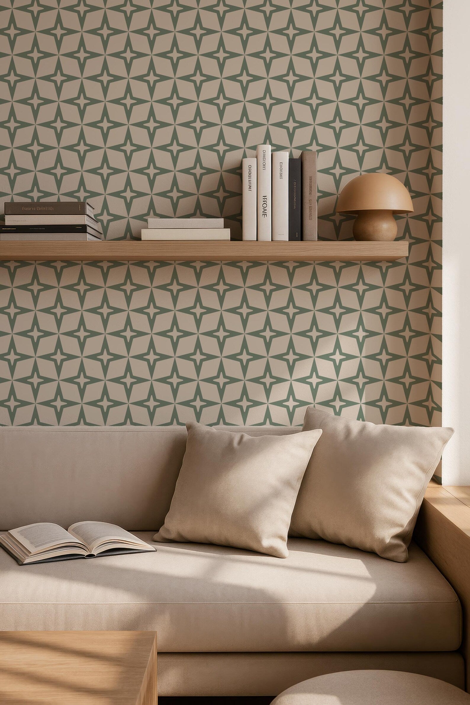 a cozy living room with a beige sofa, a wooden side table, and a bookshelf filled with books. The wall behind the sofa has a repeating pattern of green and white stars, creating a visually appealing backdrop. The room appears to be well-lit, with natural light coming in from a window.