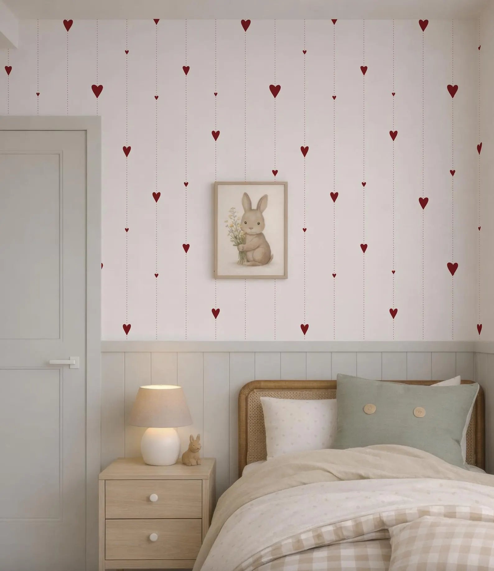 a cozy bedroom with a bed, nightstand, and a framed picture of a rabbit on the wall. The wall is decorated with red heart-shaped stickers, creating a cheerful and playful atmosphere.
