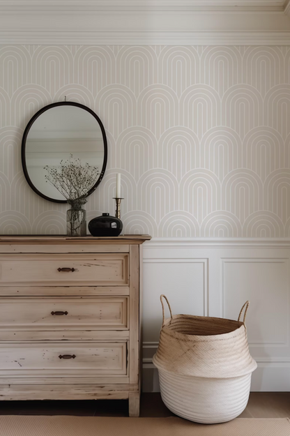 a wooden dresser with a round mirror above it, a black vase with flowers, and a woven basket on the floor next to the dresser.