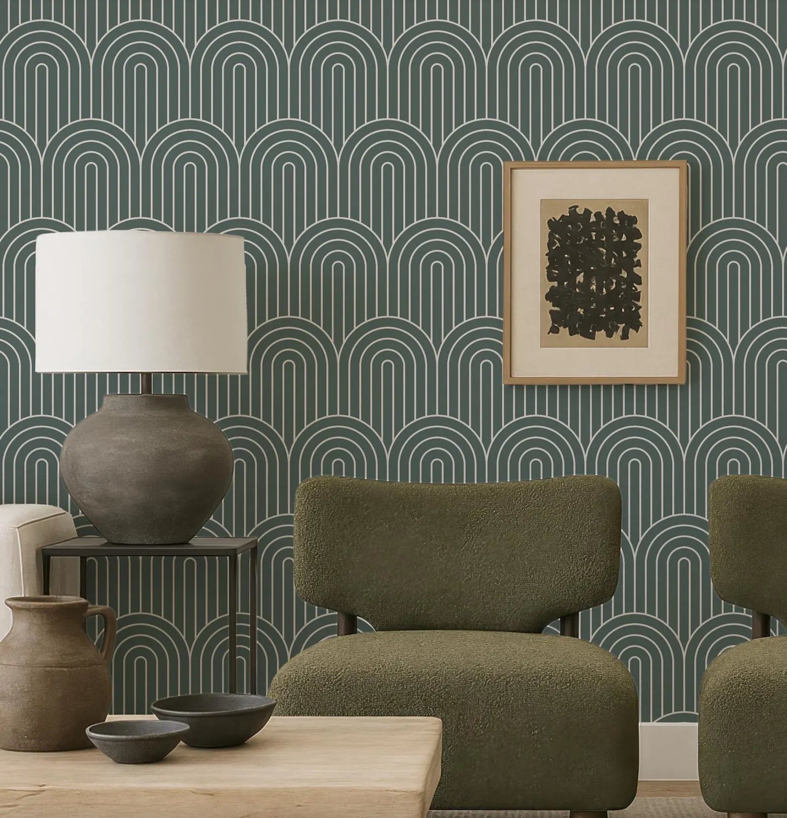 a modern living room with a green armchair, a wooden coffee table, and a lamp. The wall behind the furniture has a repeating pattern of arches in shades of green and blue, creating a visually striking backdrop. A framed abstract artwork is also present in the room, adding an artistic touch to the space.