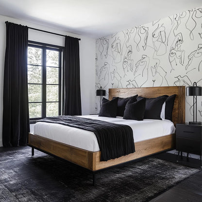 a modern bedroom with a large bed, dark curtains, and a black and white abstract wall art design.