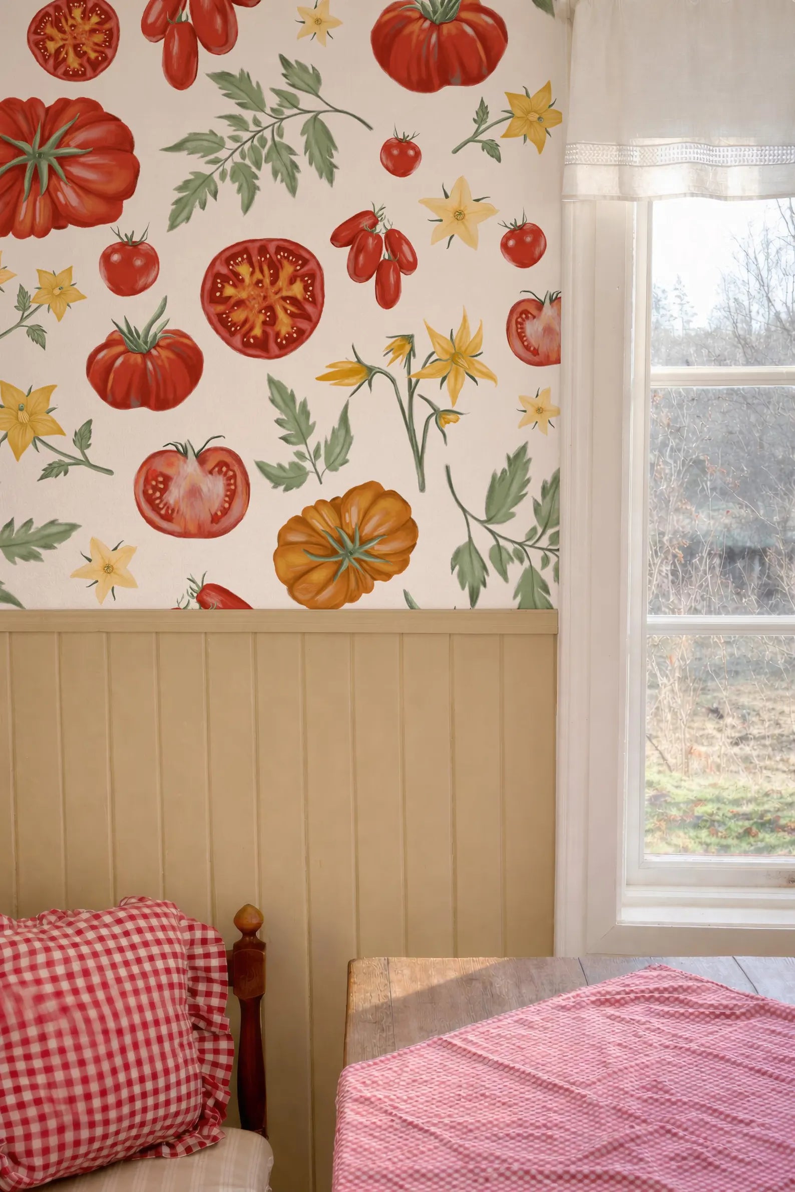 a wall with a vibrant tomato and flower pattern, and a window with a view of a garden outside.