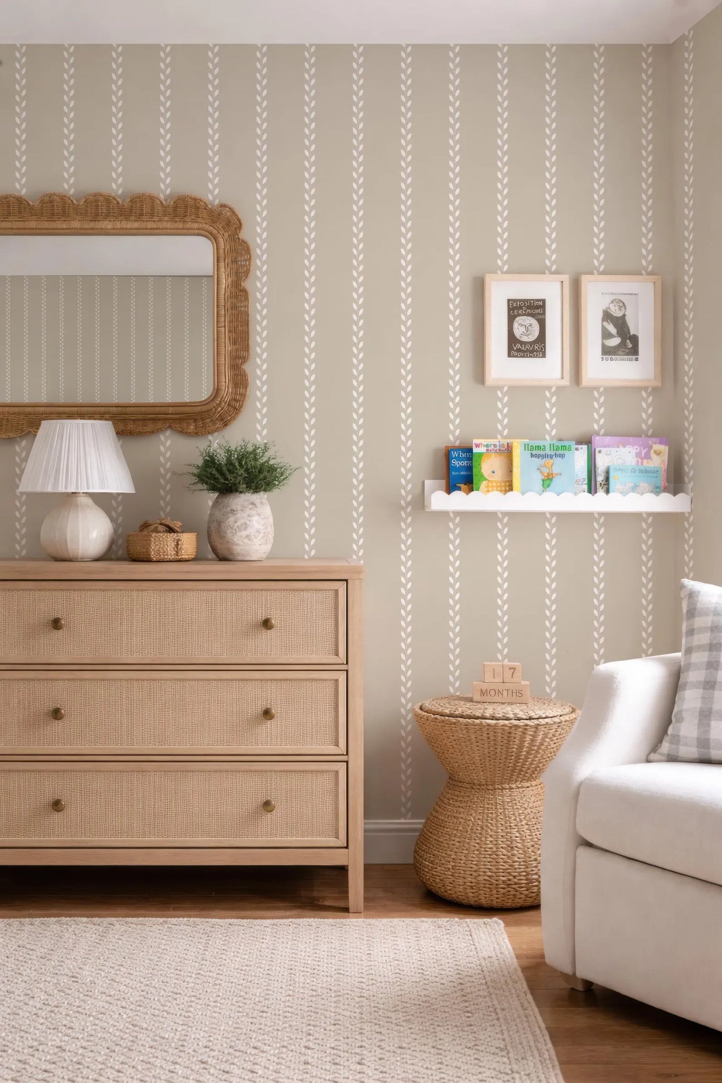 a cozy and well-decorated nursery room with a wooden dresser, a mirror, a bookshelf, and a woven side table.