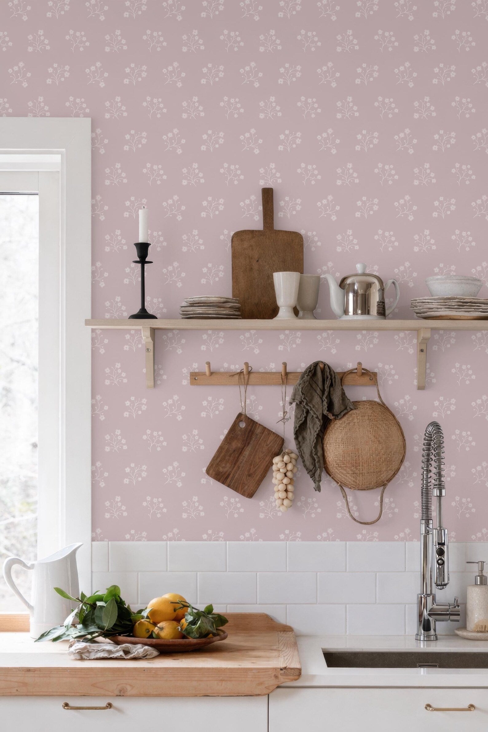 a kitchen with a pink wall, a wooden shelf with various kitchen items, and a sink with a wooden countertop.