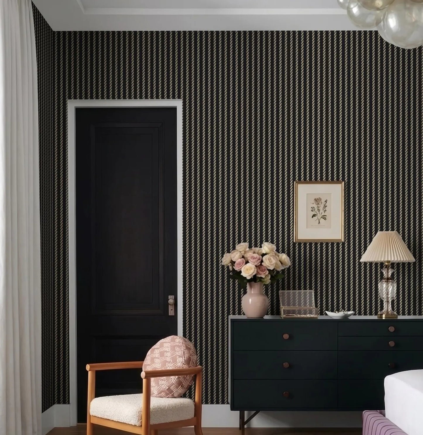 a stylish bedroom with a black and white striped wallpaper, a wooden dresser, a lamp, a vase with flowers, and a chair.