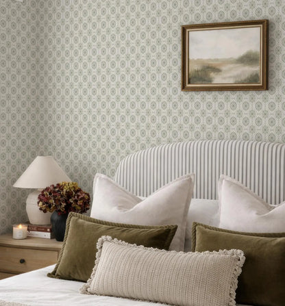 a cozy bedroom with a striped headboard, a framed landscape painting on the wall, and a bed with a white and green striped comforter and pillows.
