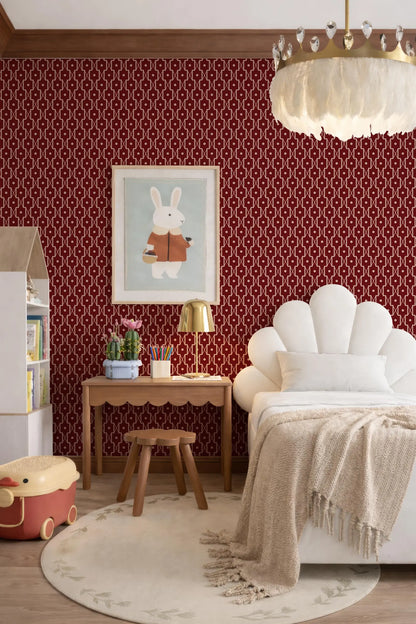 a cozy and inviting bedroom with a white bed, a wooden table, and a large red and white patterned wallpaper. The room also features a chandelier, a lamp, and a small table with a vase of flowers.