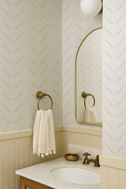 a bathroom with a white sink, a towel rack, and a mirror above the sink. The walls have a zigzag pattern, and the overall color scheme is neutral, with a white and beige color palette.